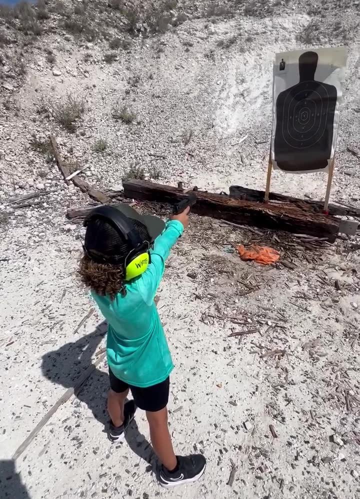 A young shooter on a supervised outdoor range with hearing protection